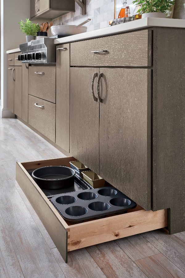 دکوراسیون آشپزخانه کوچک که برای استفاده بهتر از فضا، در قسمت پاخور کابینت های آن، کشوهای مخصوص نصب شده است